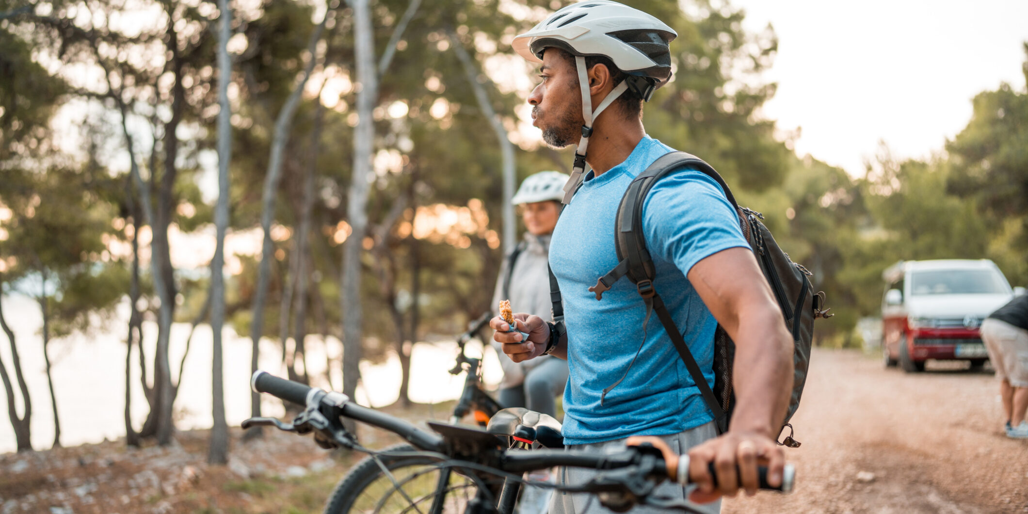 Active Black Cyclist Refuels with Snack During Sunrise Ride